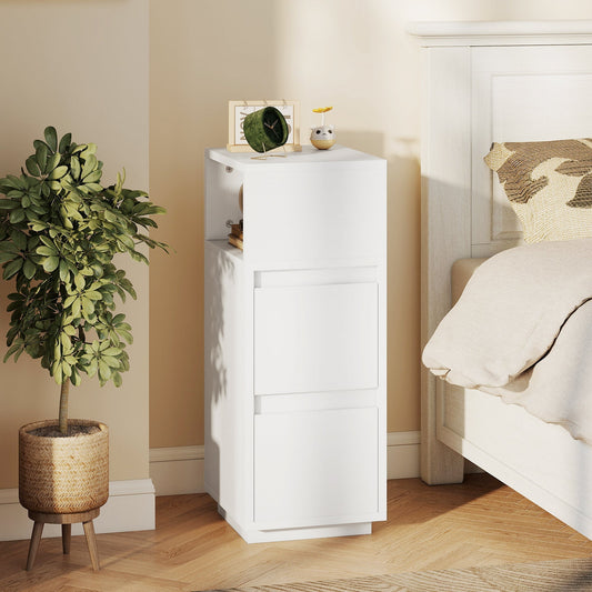 The narrow bedside cabinet is placed next to a bed with a plant beside it