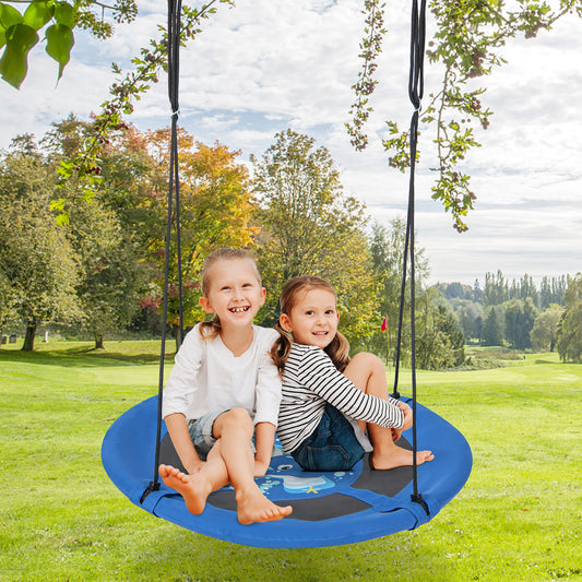 Two smiling young girls sitting on the blue saucer swing in a garden setting