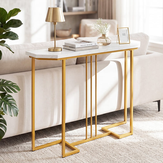 Console table with a faux marble top and gold legs placed behind a sofa