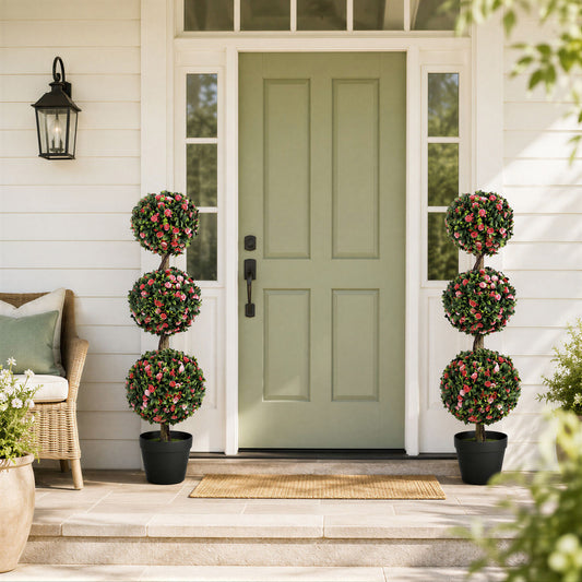 Two artificial rose topiary trees flanking a doorway on a porch