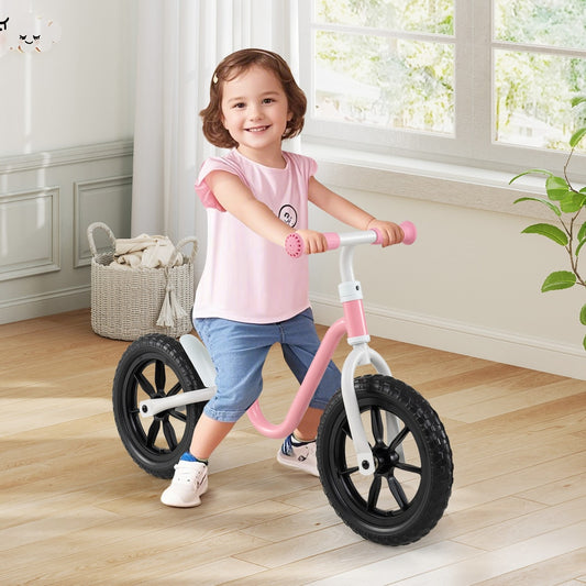 A young girl smiling while sitting on the balance bike inside a bright living room