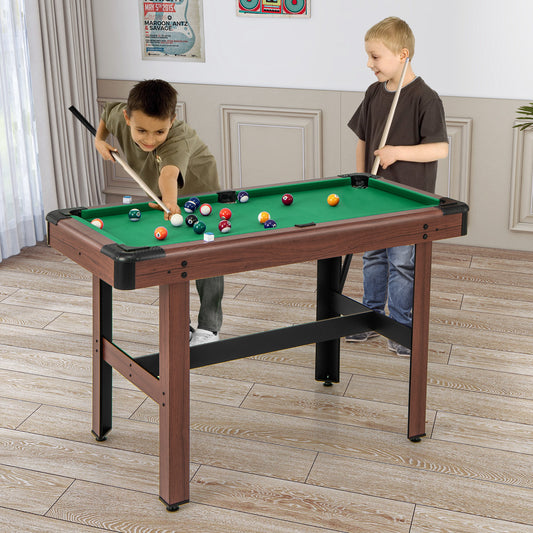 Two children playing a game of pool on the green wooden pool table in a room