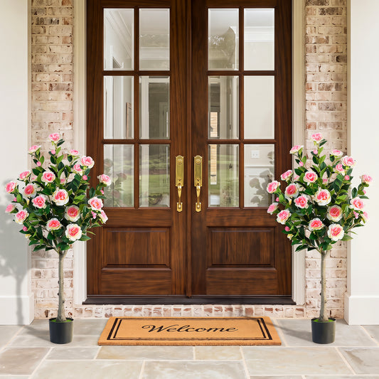 Two artificial camellia trees flanking a doorway