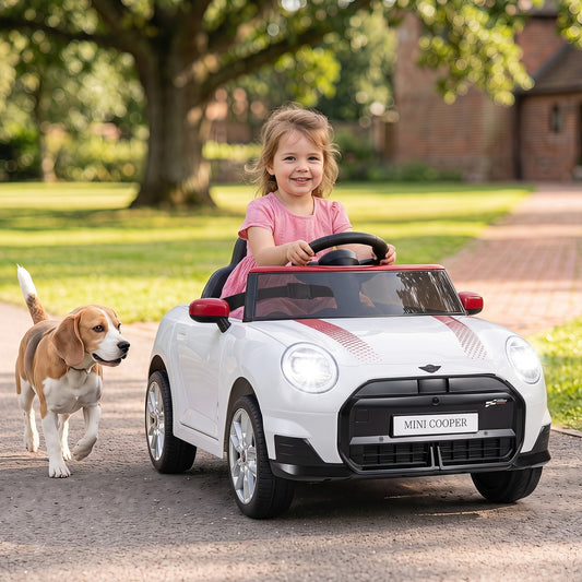 The white kids electric car with a beagle dog running alongside it on a path