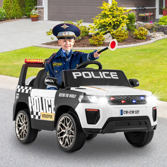 A young boy in a police hat sits in the white electric police car, holding a stop sign