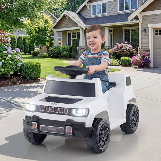 A happy toddler boy driving the white electric jeep car in a suburban garden