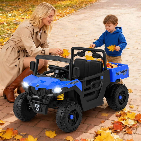 A woman and a child playing with the blue electric ride on truck outdoors