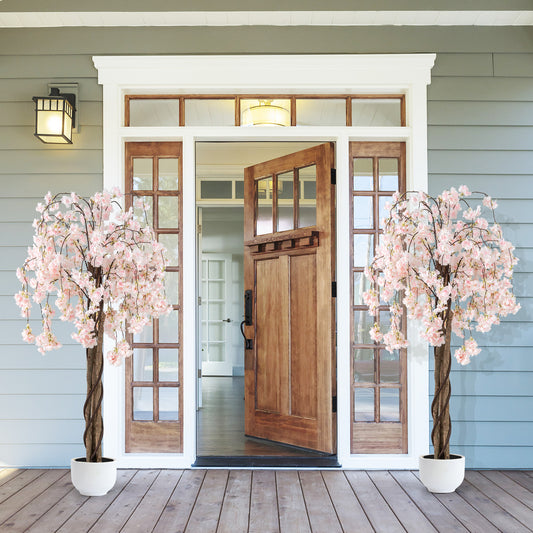 Two artificial cherry blossom trees flanking a doorway, one on each side