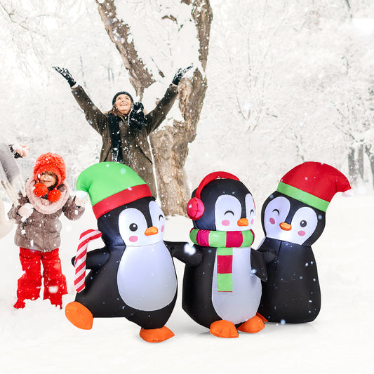 The Christmas inflatable penguins in a snowy garden with people