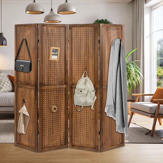 The folding room divider is set up in a living room with items hung on it