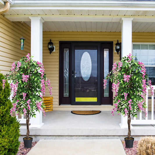 Front porch with decorative plants and a black door with a circular window.