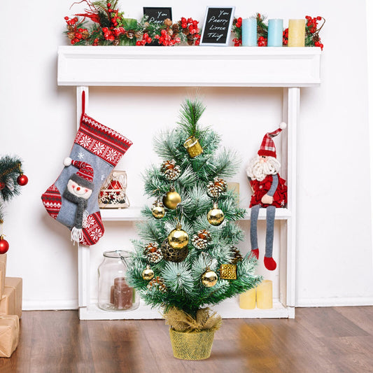 The small Christmas tree decorated with baubles on a shelf with stockings and a Santa figure