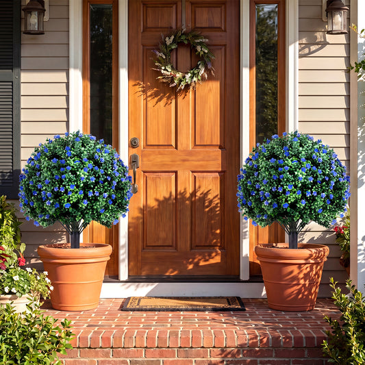 Two artificial camellia boxwood topiary ball trees in large pots flanking a doorway