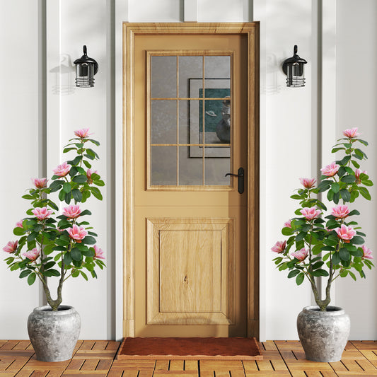 The faux plants placed in decorative stone pots on either side of a wooden front door