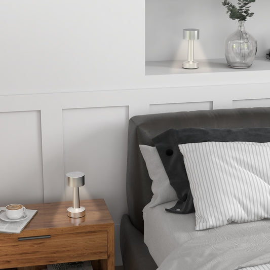 The cordless table lamp on a bedside table next to a bed