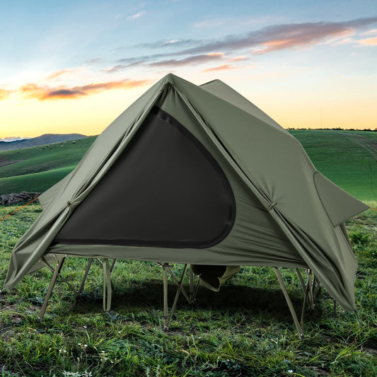 the green camping cot tent pitched on grass with a man pulling a wheeled bag