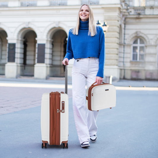 the white travel cases being pulled by a woman walking through a city square