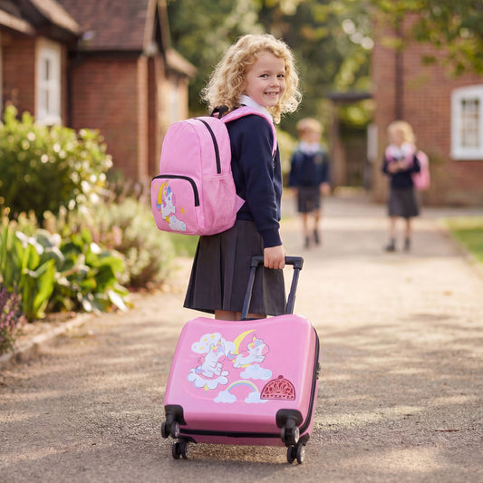 A young girl smiles pulling a pink kids luggage set with a matching backpack