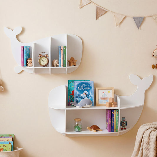 Two white whale shaped wall shelves mounted on a beige wall holding books and small ornaments