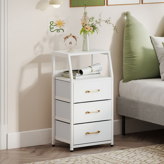 The white storage dresser with gold handles is placed next to a bed in a bedroom setting
