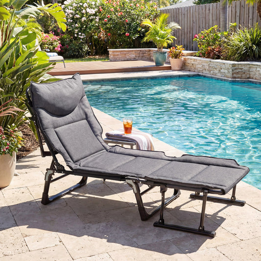 The camping cot as a recliner by a swimming pool with a drink on a side table