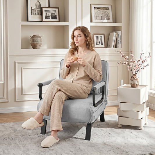 Light grey sofa bed in a living room with a woman sitting on it drinking tea