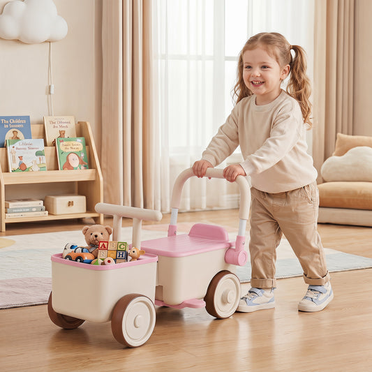 A happy toddler pushes the pink ride on car with a storage basket full of toys