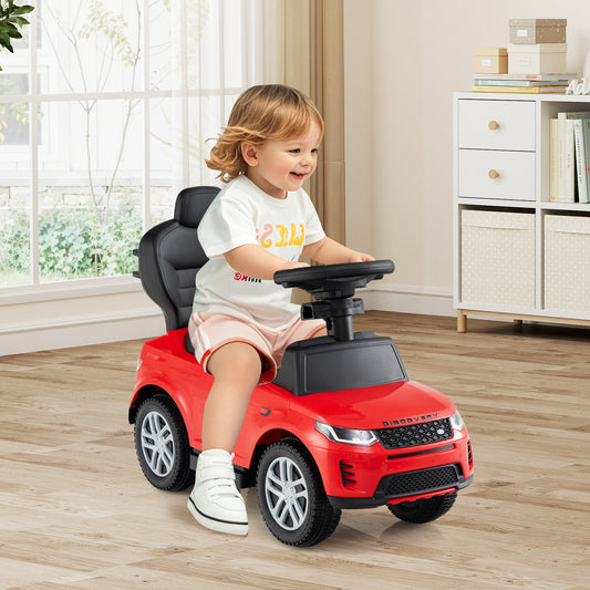 Toddler smiling while steering the red ride on toy car indoors