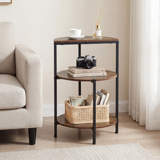 The round side table with storage shelves is placed next to a sofa with a cup and camera on top