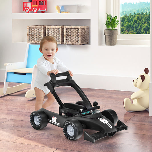 A baby sits in the black baby walker, which resembles a racing car