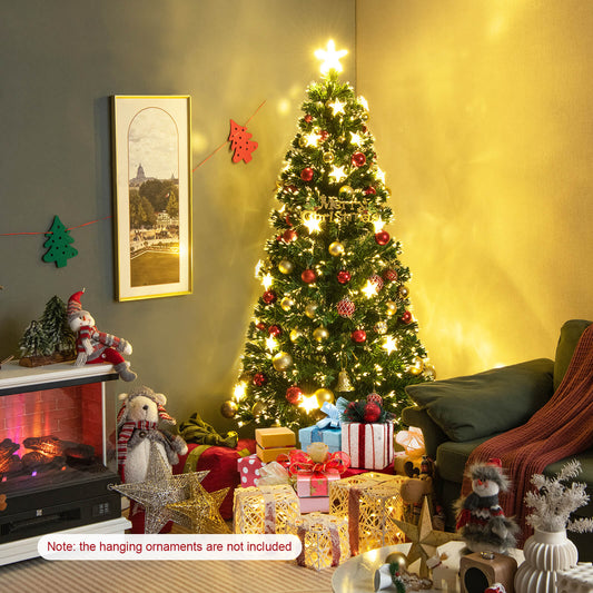 The artificial tree decorated with baubles and gifts in a cosy living room next to a fireplace