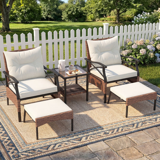 The patio furniture set arranged on a rug in a garden setting with a white picket fence