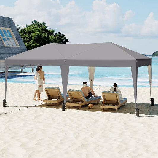 The grey canopy tent provides shade for people relaxing on sun loungers at the beach