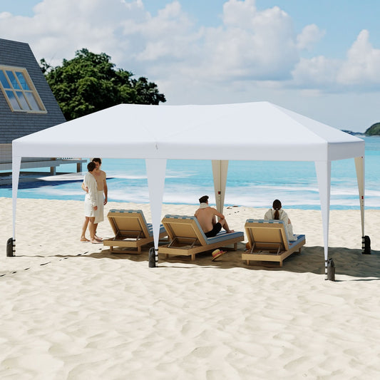 The white pop up canopy tent providing shade on a sandy beach with loungers and people relaxing