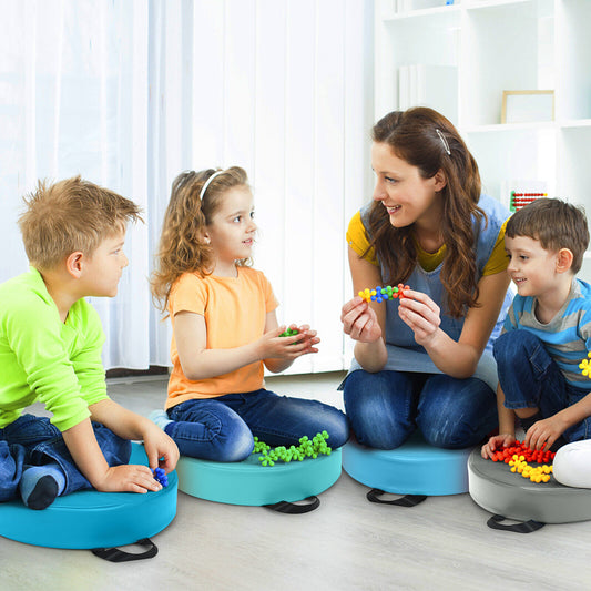 A teacher and three children sitting on colourful floor cushions during a lesson