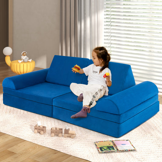 A young child sits on the blue modular play couch sofa, playing with toys