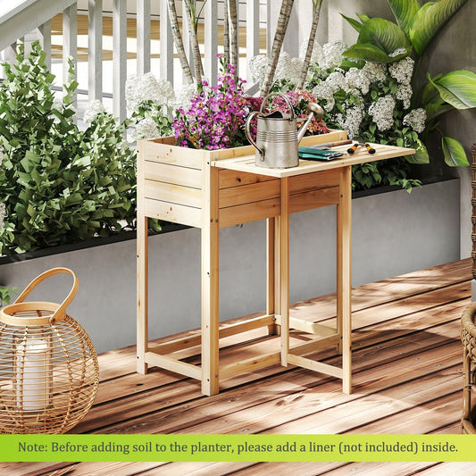 The raised garden bed with legs and side table on a wooden deck, with plants and a watering can