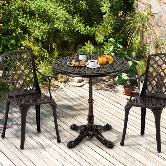 The patio table set with two matching chairs on a wooden deck surrounded by lush green plants