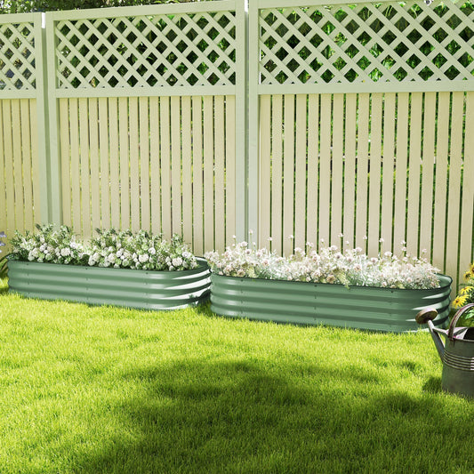 Two green galvanised raised garden beds filled with flowers, sitting on a lawn