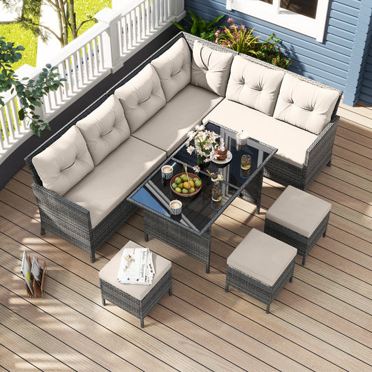 The patio furniture set arranged on a wooden balcony deck with a view of a garden