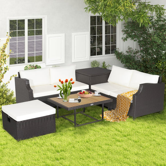 The patio furniture set arranged on a green lawn with a vase of flowers on the coffee table