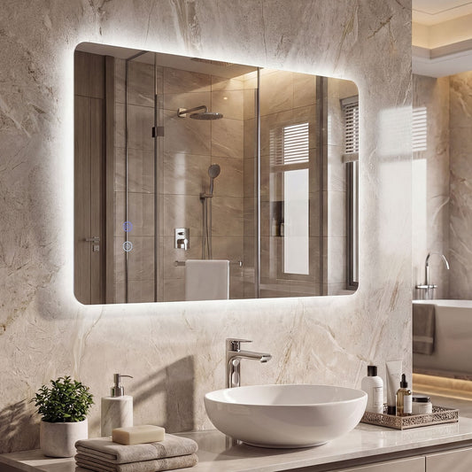 The illuminated wall mirror above a white basin and toiletries in a bathroom