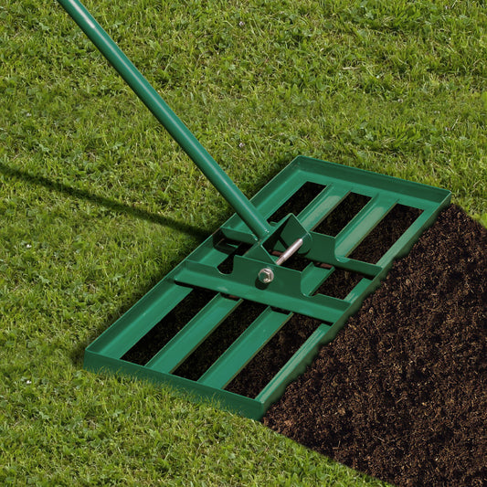 The lawn leveling rake being used to spread soil on grass