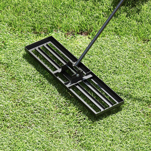 The lawn leveling rake being used on a grassy lawn, showing its practical application