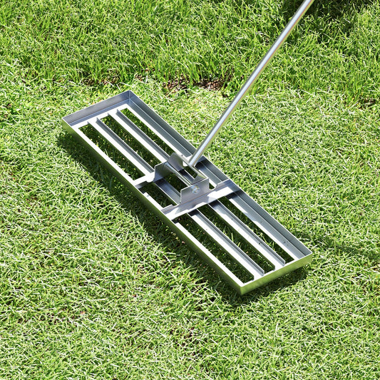 The lawn leveling rake on green grass, showing the base and handle