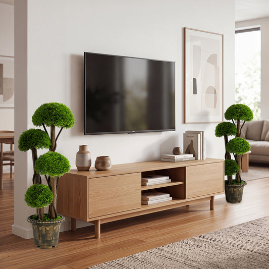 Two faux plants in decorative planters flanking a modern media unit with a television