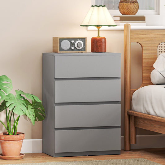 The grey chest of drawers in a bedroom setting next to a bed and plant