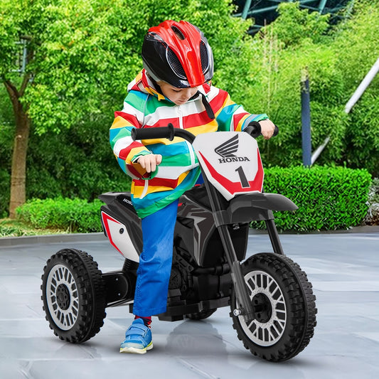 Child wearing a helmet rides the grey kids electric motorbike outdoors