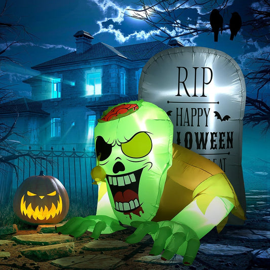 The Halloween inflatable ghost and tombstone set up in a garden at night with a pumpkin lantern