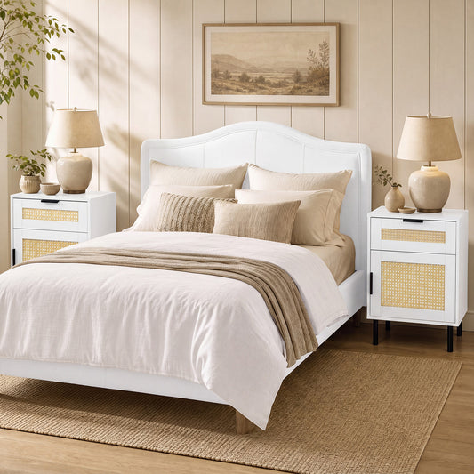 Two white bedside tables with rattan detail in a bedroom setting